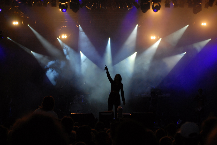 Silhouette of singer performing on stage under spotlights